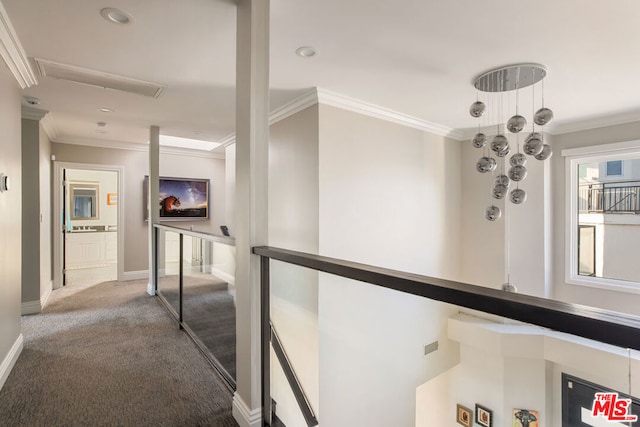 hallway with ornamental molding and carpet