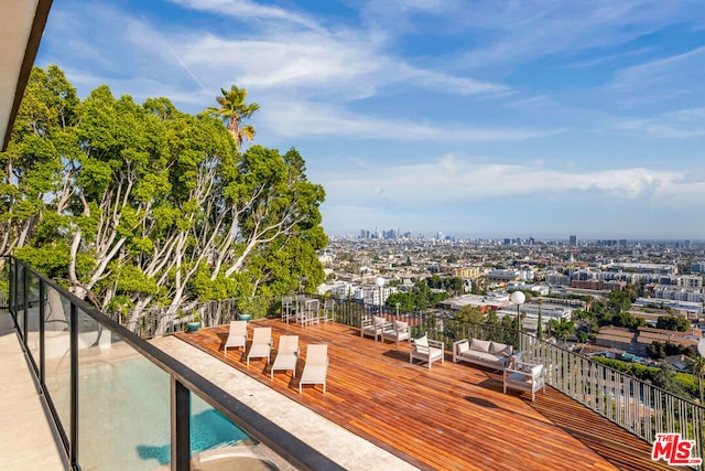 wooden deck with outdoor lounge area and a community pool