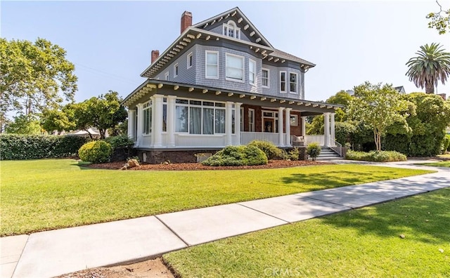 victorian home with a front yard and covered porch