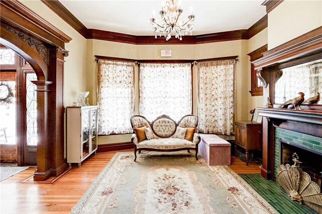 455 W 20th St, Merced, CA 95340 - living area with ornate columns, an inviting chandelier, a brick fireplace, light wood-type flooring, and ornamental molding