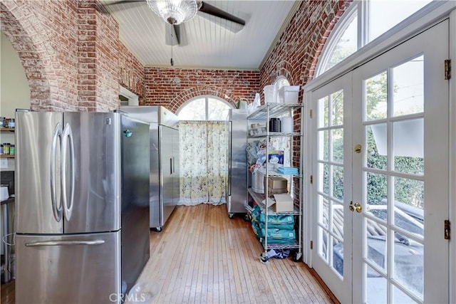 455 W 20th St, Merced, CA 95340 - kitchen featuring stainless steel refrigerator, a healthy amount of sunlight, brick wall, and light hardwood / wood-style flooring