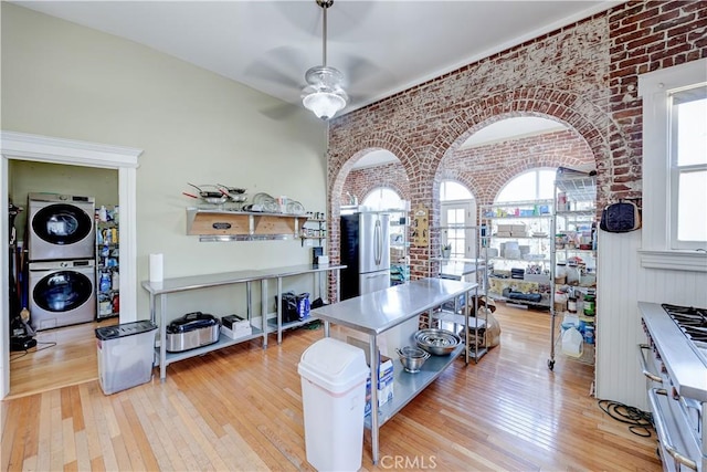 455 W 20th St, Merced, CA 95340 - interior space featuring stacked washer and dryer, ceiling fan, brick wall, and light wood-type flooring