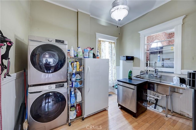 455 W 20th St, Merced, CA 95340 - clothes washing area featuring stacked washer and dryer, crown molding, and light hardwood / wood-style floors