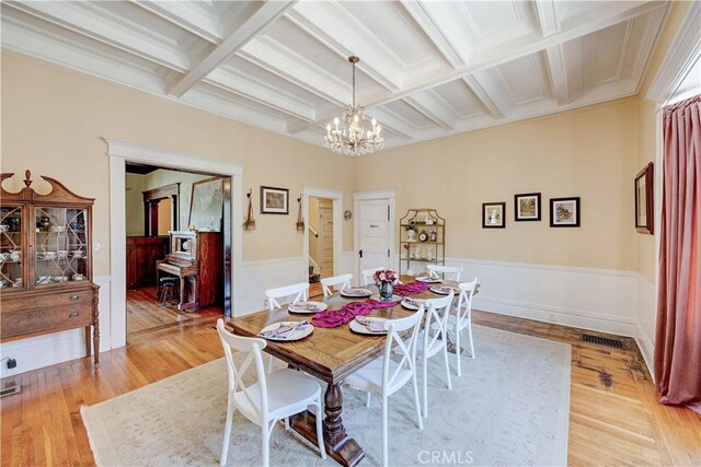 455 W 20th St, Merced, CA 95340 - dining area featuring coffered ceiling, a notable chandelier, beam ceiling, and light hardwood / wood-style floors