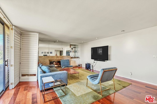 living room with a tile fireplace and hardwood / wood-style floors