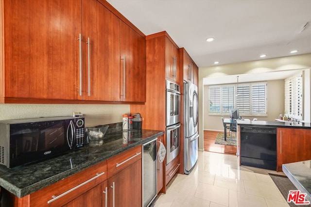 kitchen with black appliances, dark stone countertops, and light tile patterned floors