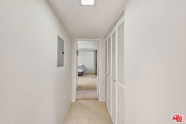 corridor with electric panel and light tile patterned flooring