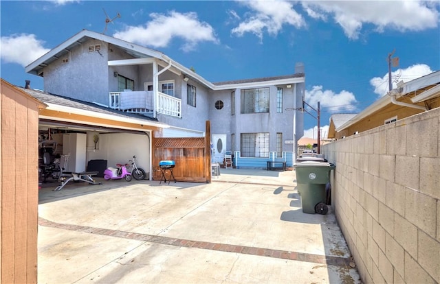 rear view of house with a balcony and a patio area