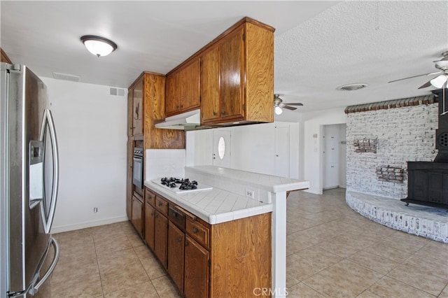 kitchen featuring ceiling fan, light tile patterned floors, and stainless steel fridge