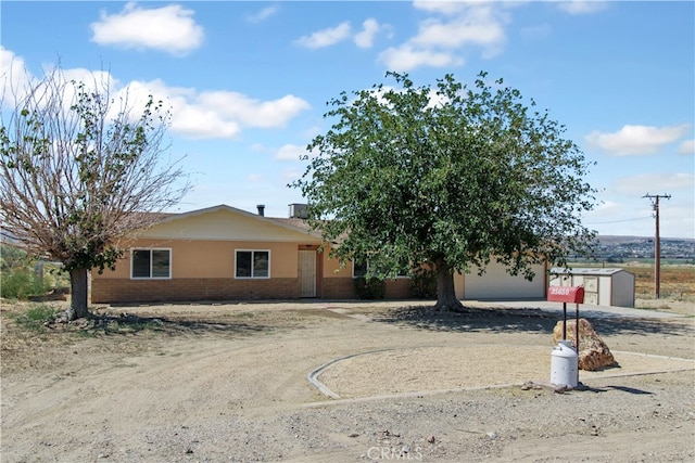 single story home featuring a shed and a garage