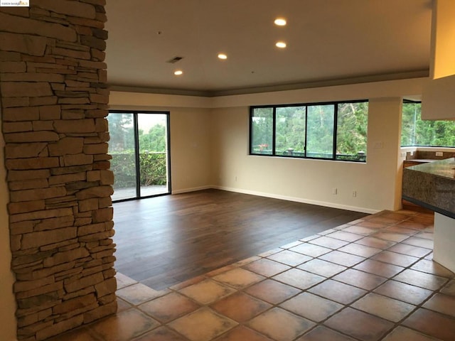 unfurnished living room featuring wood-type flooring and ornamental molding