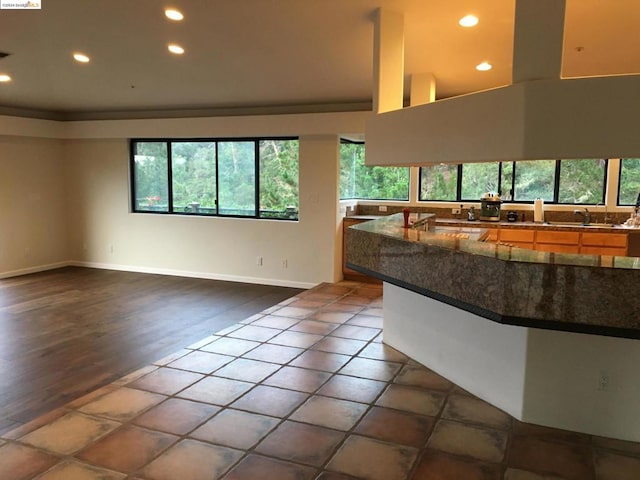 kitchen featuring a high ceiling, kitchen peninsula, and dark wood-type flooring