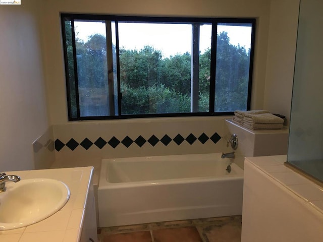 bathroom with vanity and a bath