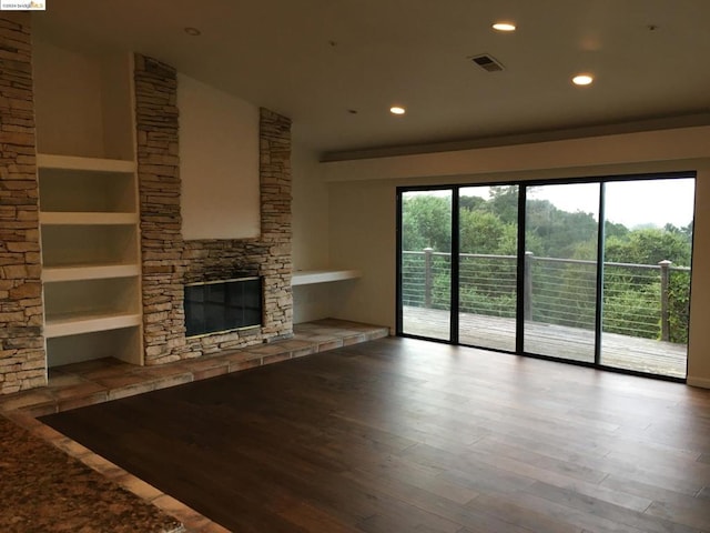 unfurnished living room with a wealth of natural light, lofted ceiling, a fireplace, and hardwood / wood-style floors