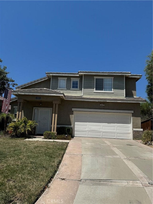 view of front of property featuring a garage and a front lawn