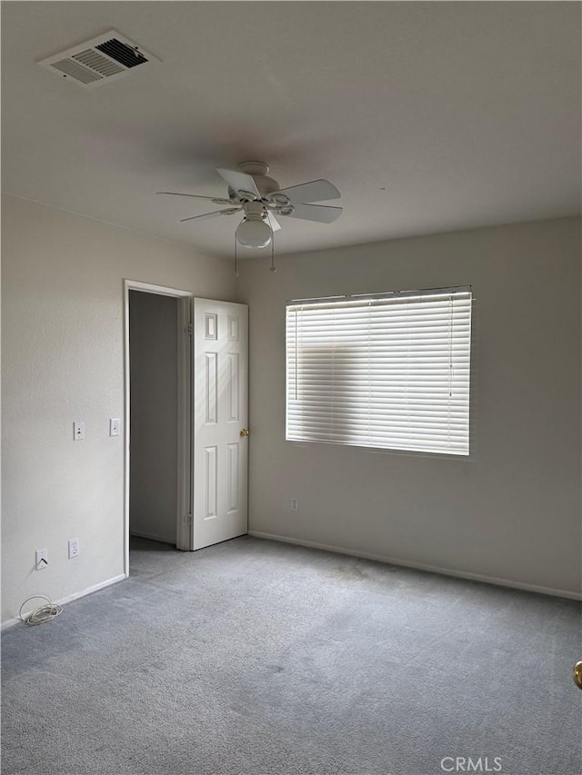 empty room with ceiling fan and light colored carpet