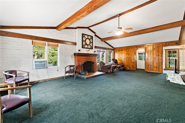 carpeted living room featuring ceiling fan, a wealth of natural light, vaulted ceiling with beams, and a brick fireplace