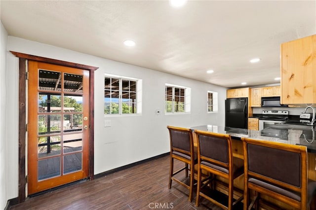 kitchen featuring dark hardwood / wood-style flooring, tile countertops, light brown cabinetry, black appliances, and sink