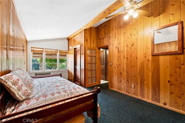 bedroom featuring ceiling fan, wooden walls, carpet flooring, and vaulted ceiling