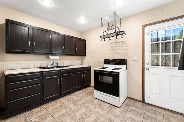 kitchen featuring white range with electric cooktop, sink, and light tile patterned flooring