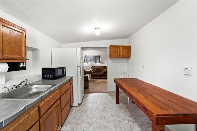 kitchen featuring sink, vaulted ceiling, and light tile patterned floors