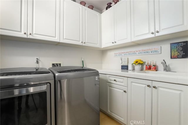 laundry area with washer and dryer, sink, and cabinets