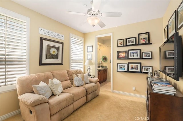 carpeted living room with ceiling fan