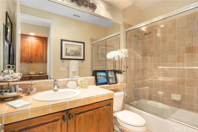 full bathroom featuring vanity, toilet, and combined bath / shower with glass door