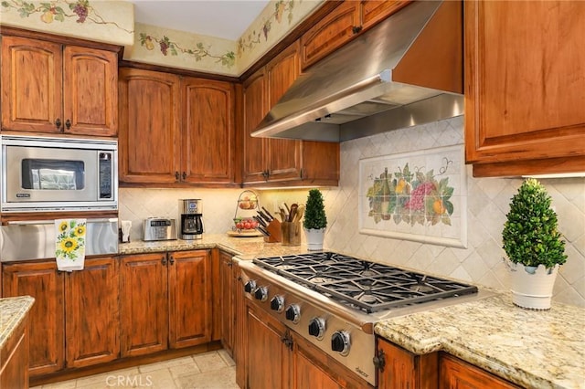 kitchen with stainless steel appliances, light stone countertops, extractor fan, and backsplash