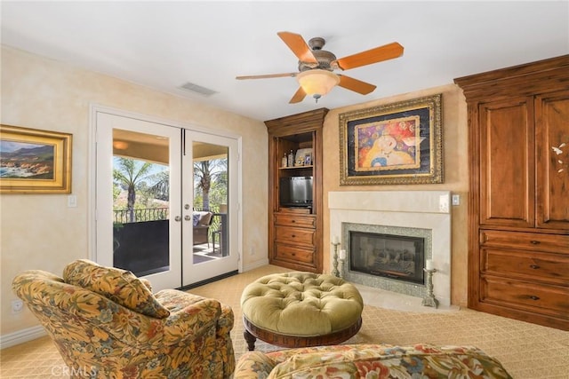 living room featuring french doors, ceiling fan, and built in shelves