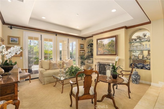 sitting room featuring crown molding, a tray ceiling, light tile patterned flooring, and built in features