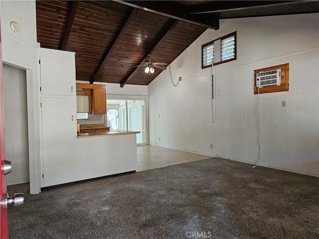 unfurnished living room featuring beamed ceiling, plenty of natural light, ceiling fan, and wood ceiling