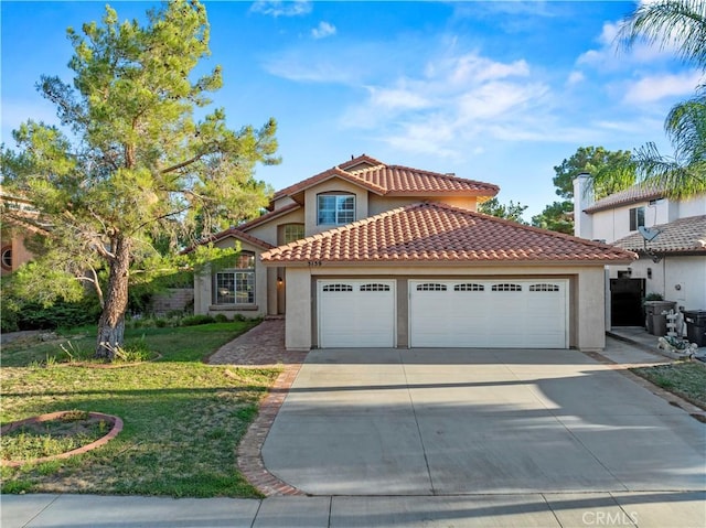 mediterranean / spanish house with a garage and a front lawn