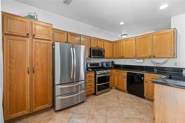 kitchen featuring light tile patterned flooring, stainless steel appliances, and sink