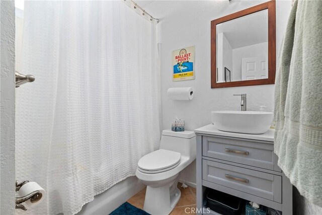 full bathroom with shower / tub combo with curtain, toilet, tile patterned floors, and vanity