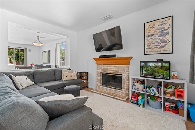 living room featuring carpet and a brick fireplace