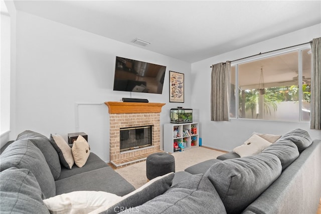 living room featuring a brick fireplace and carpet