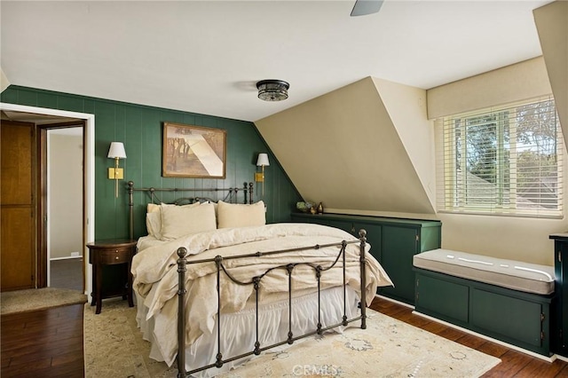 bedroom with dark hardwood / wood-style flooring, ceiling fan, and lofted ceiling