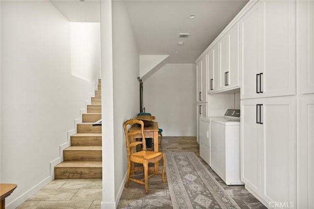 washroom featuring washer and dryer and cabinets