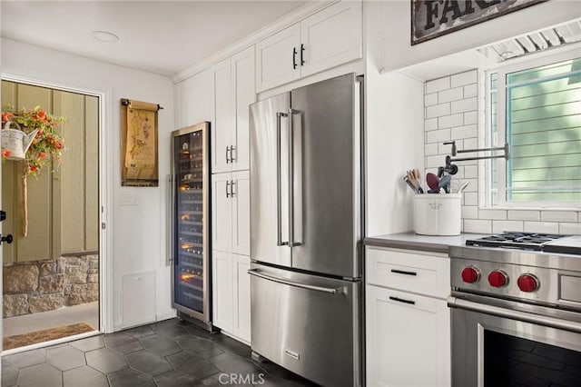 kitchen featuring backsplash, white cabinetry, beverage cooler, and premium appliances