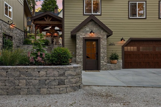 exterior entry at dusk featuring a garage