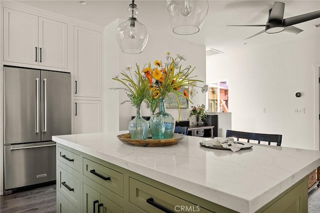 kitchen with high end fridge, ceiling fan, dark wood-type flooring, green cabinetry, and a kitchen island