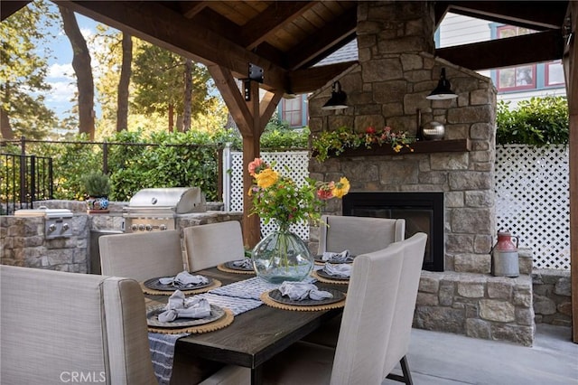 view of patio / terrace with area for grilling, exterior kitchen, and an outdoor stone fireplace