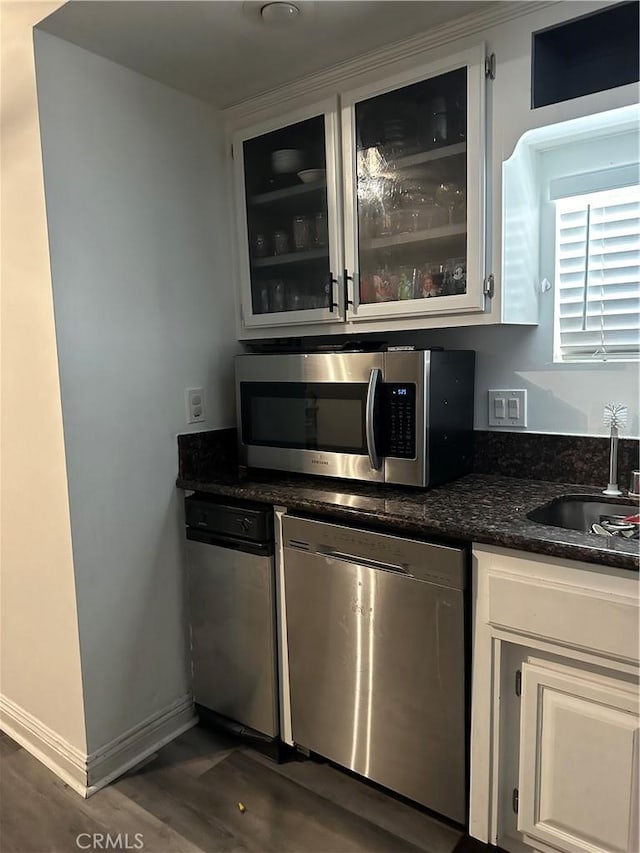 kitchen with sink, dark wood-type flooring, stainless steel appliances, and white cabinets