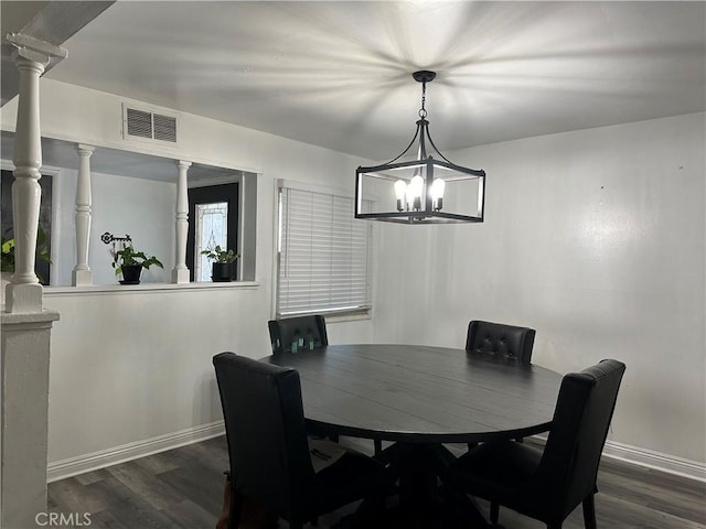 dining room featuring decorative columns and dark wood-type flooring