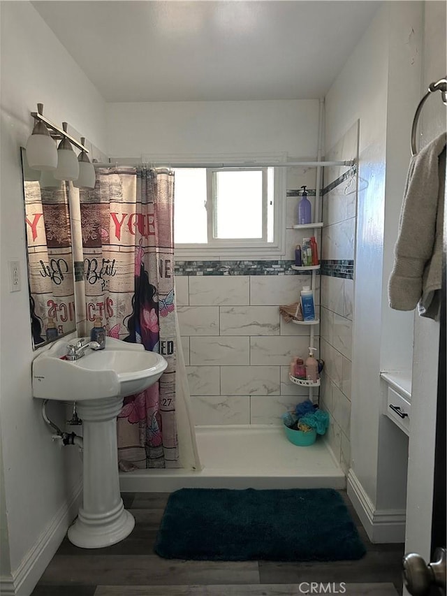 bathroom featuring hardwood / wood-style floors, curtained shower, and sink