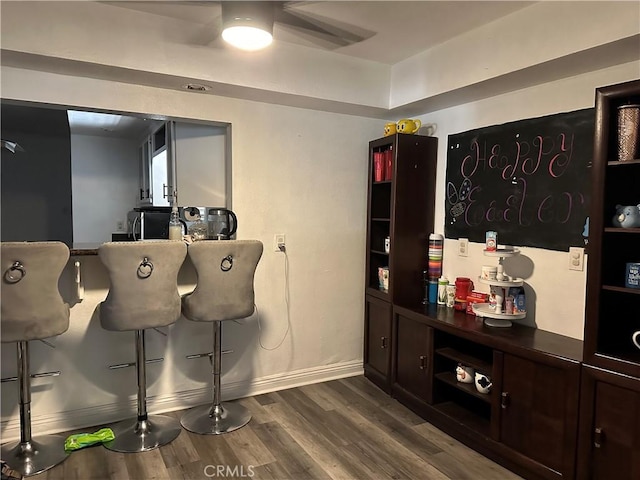 bar with wood-type flooring and dark brown cabinets