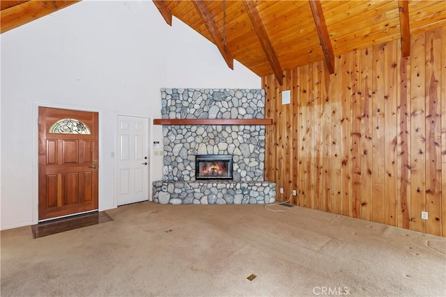 unfurnished living room with beam ceiling, carpet flooring, high vaulted ceiling, wood walls, and a fireplace