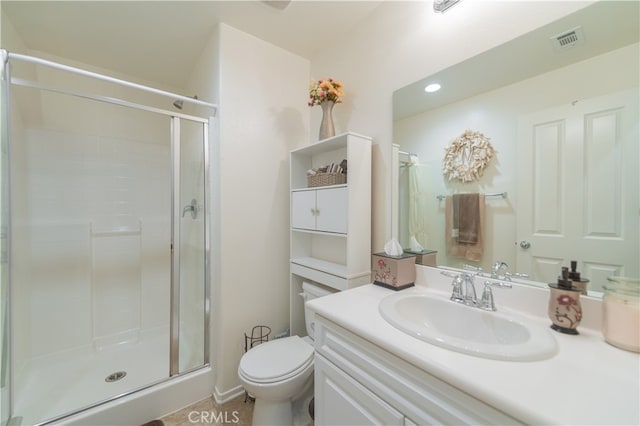 bathroom with a shower with door, vanity, tile patterned flooring, and toilet