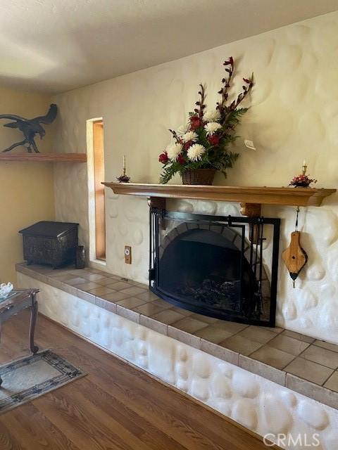 room details with a tile fireplace and wood-type flooring